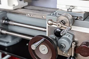 Carriage and controls of a metalworking lathe used for machining