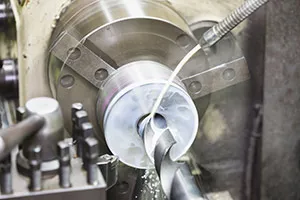 Metal part being drilled by a machine