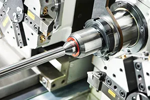 Metal rod being turned on a CNC cutting machine tool in a manufacturing factory