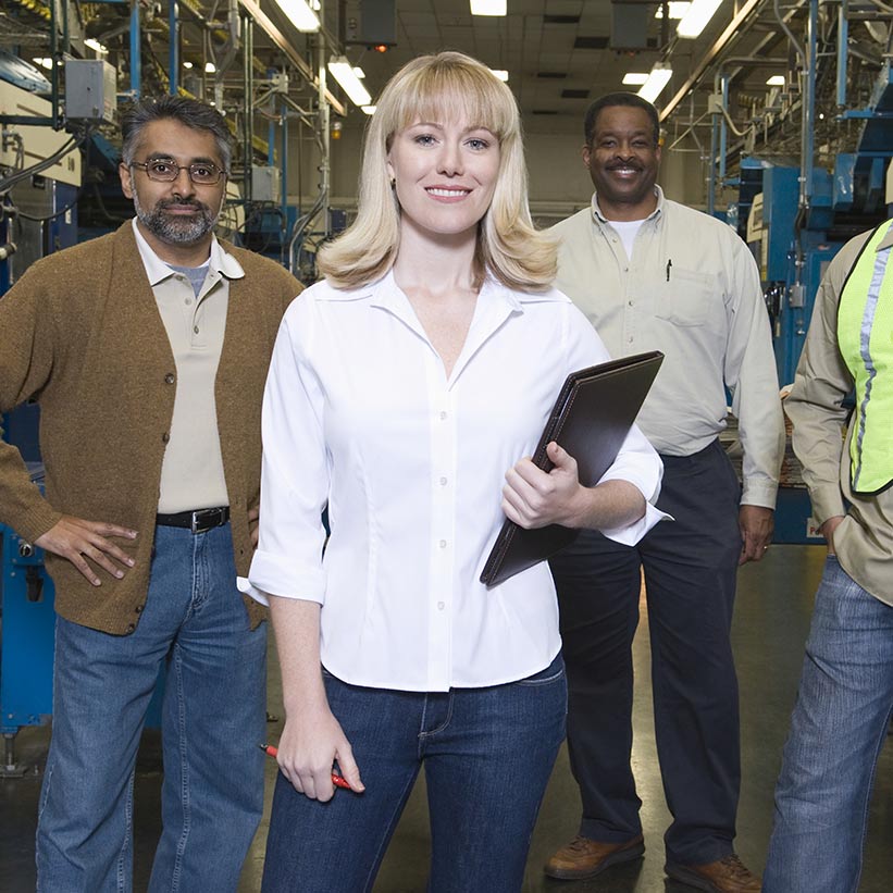 A group of diverse industrial workers or engineers in a manufacturing setting