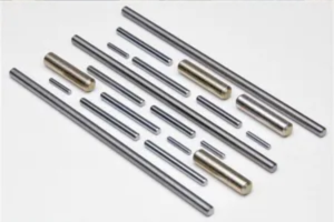 A collection of various metal dowel pins or precision metal shafts of different lengths and diameters